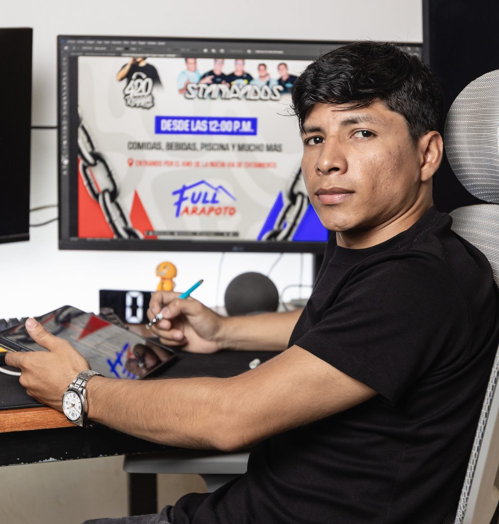 Diseñador de Gokiebox frente a una pieza gráfica abierta en Photoshop, con su tableta y lápiz
