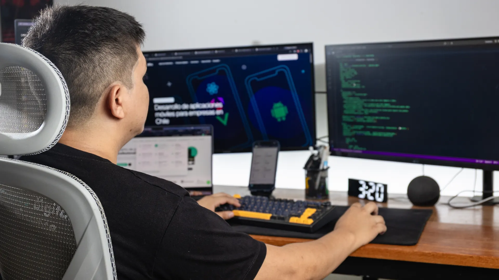 Desarrollador de Gokiebox programando una página web frente a dos monitores con diseño y código